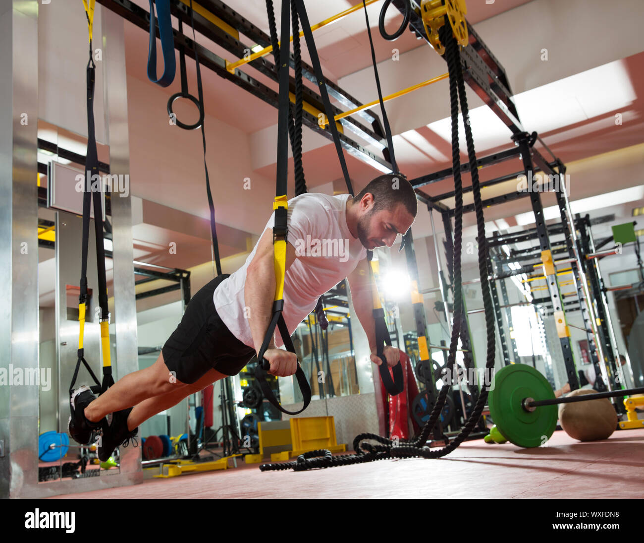 Fitness Crossfit TRX empuje ups hombre ejercitarse en el gimnasio  Fotografía de stock - Alamy