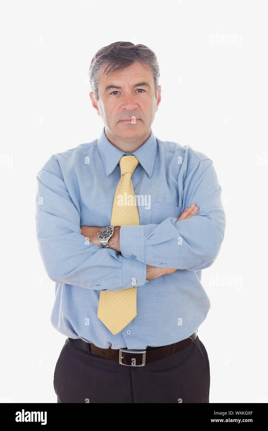 Retrato de confianza empresario maduro de pie con los brazos cruzados contra el fondo blanco. Foto de stock