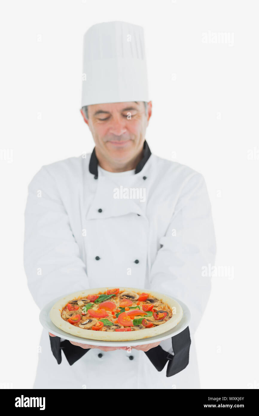 Chef madura ofrece pizza sobre fondo blanco. Foto de stock