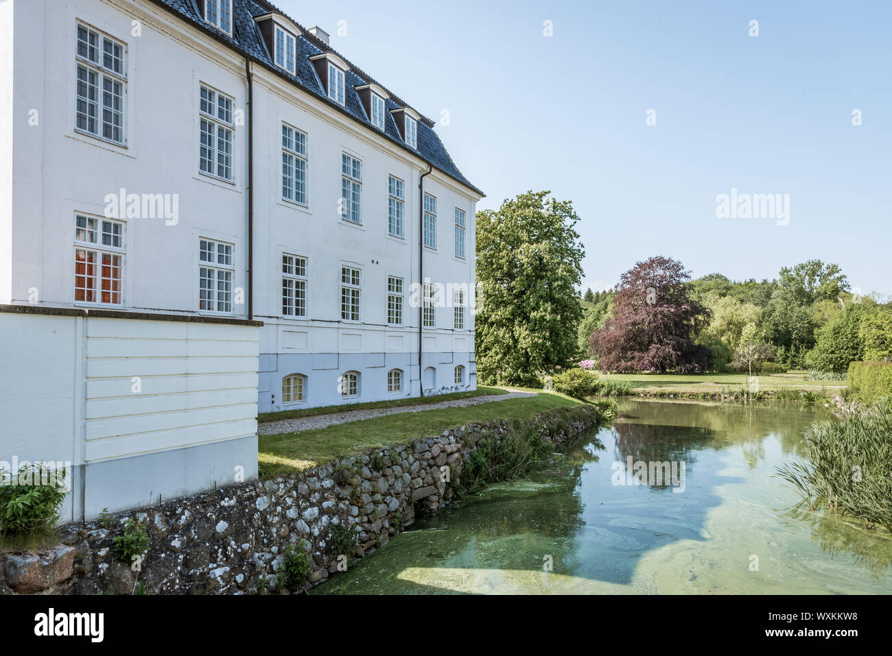 Hvidkilde Castillo en el sur de Funen, un gran edificio blanco con un foso, Fionia, Dinamarca, 12 de julio de 2019 Foto de stock