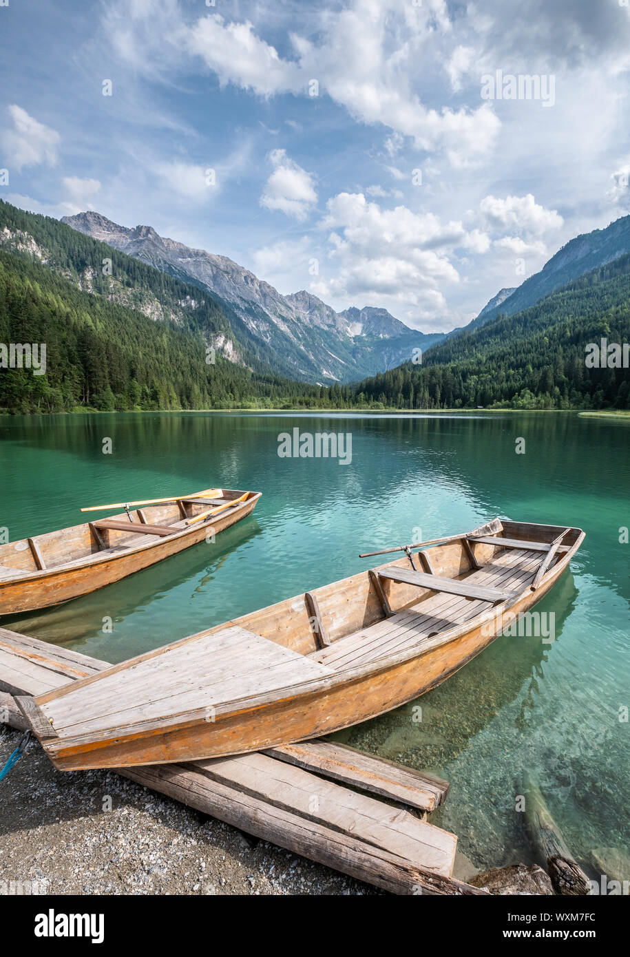 Pintoresco paisaje de montaña con botes de madera y turquesa del lago en un día soleado de verano en Austria Alpes Foto de stock
