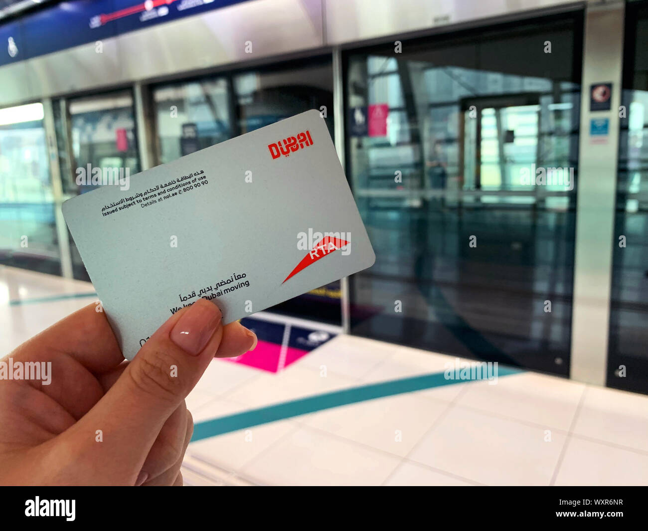 Dubai - Emiratos Árabes Unidos - 17 de septiembre de 2019: Una mujer sostiene NOL tarjeta de metro mientras espera el tren del metro en Dubai Foto de stock