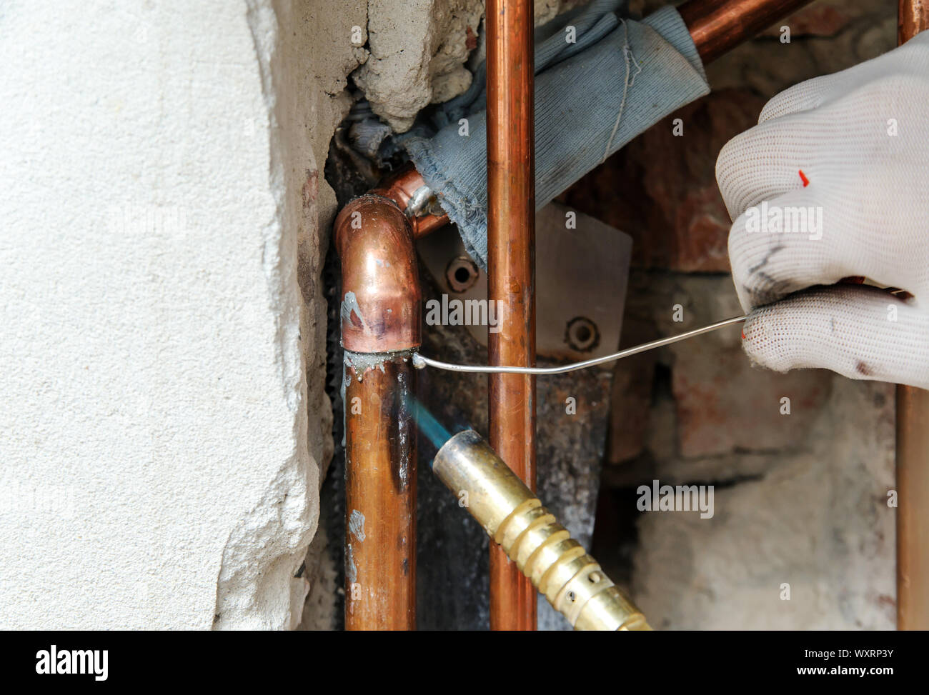 Un trabajador está usando el quemador de gas y la soldadura para soldar  tubos de cobre Fotografía de stock - Alamy