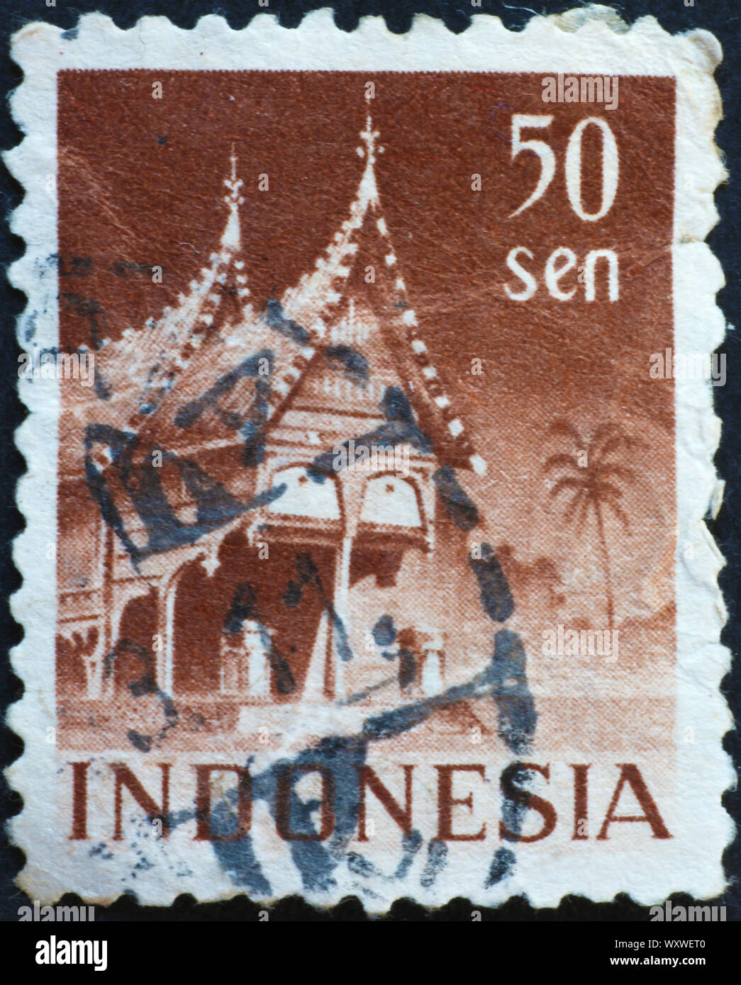 Casa de madera tradicional de Indonesia sobre la estampilla postal Foto de stock