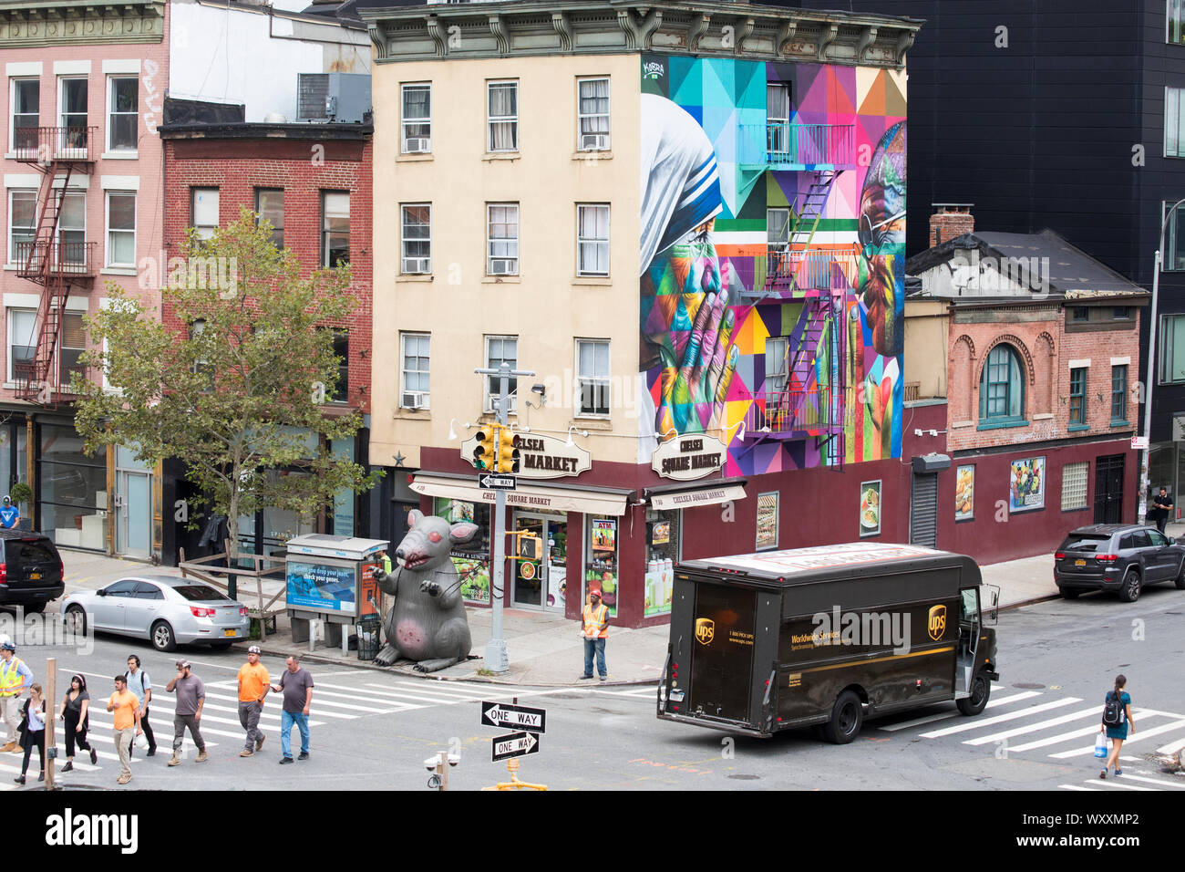 Esquina de la calle escena con UPS courier camión de entrega, semáforos, mural y Chelsea Plaza del Mercado tienda en West 18th Street y Tenth Avenue en Nueva Foto de stock