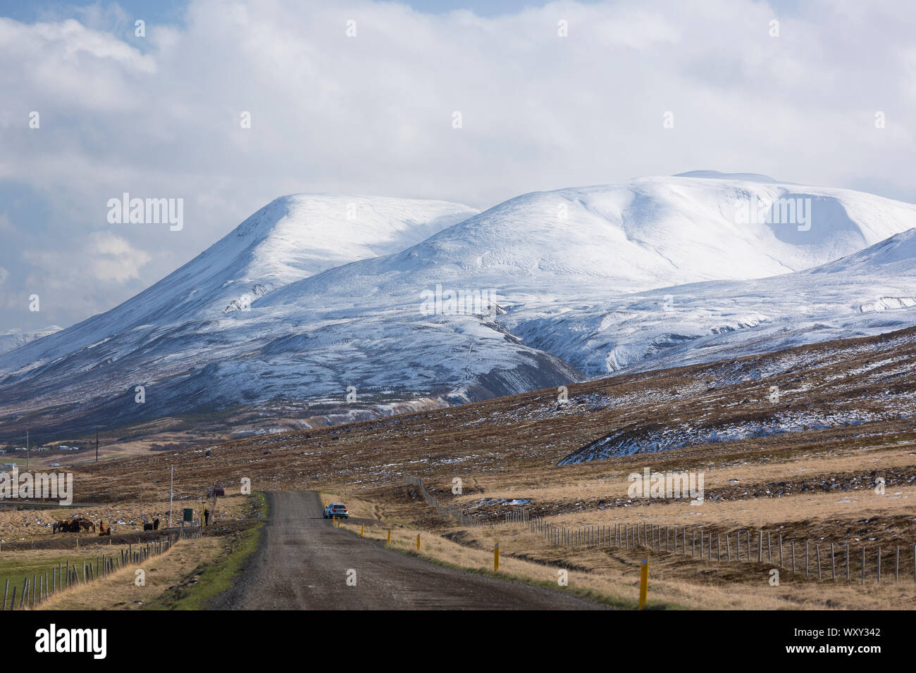 SAUDARKROKUR, Islandia - camino de tierra y el paisaje de las montañas cubiertas de nieve en el norte de Islandia. Foto de stock