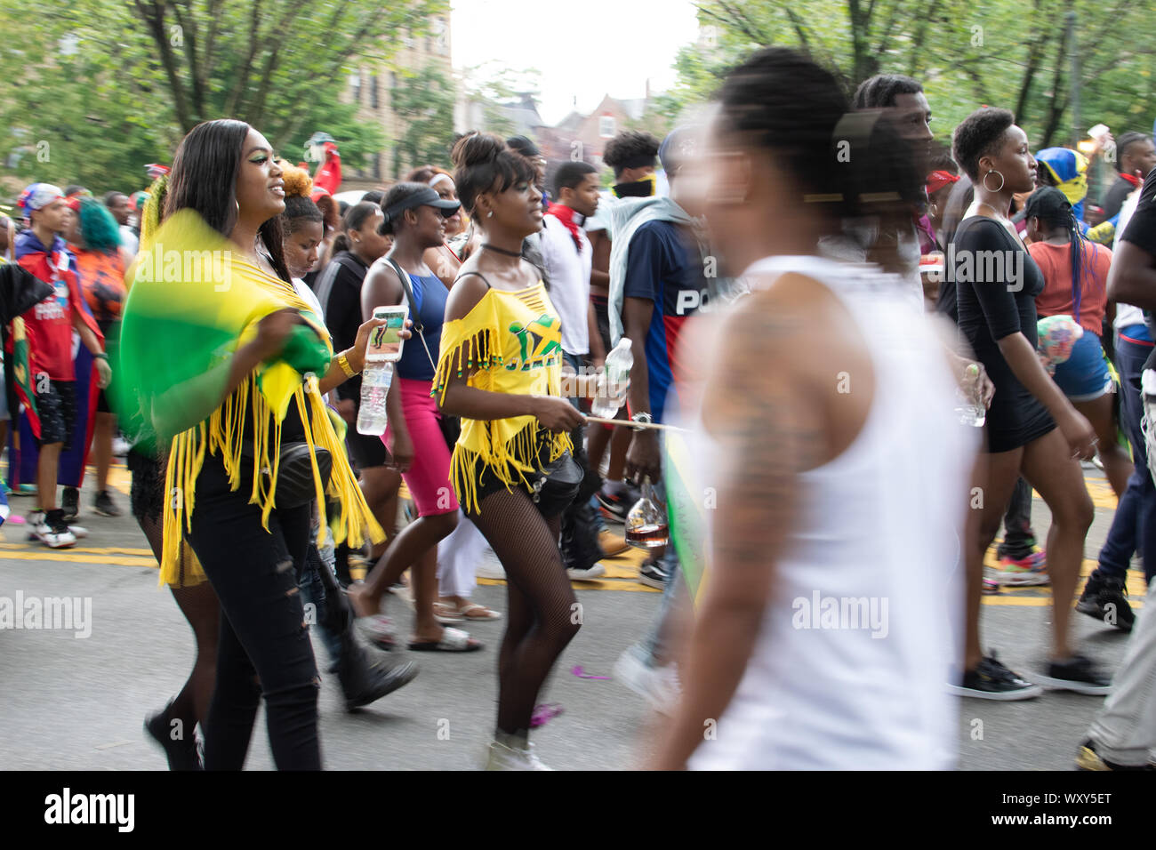 Tanzend zu lauter Musik laufen Teilnehmer der West Indian Day Parade en la Ciudad de Nueva York un den Zuschauern vorbei und animieren diese. Foto de stock