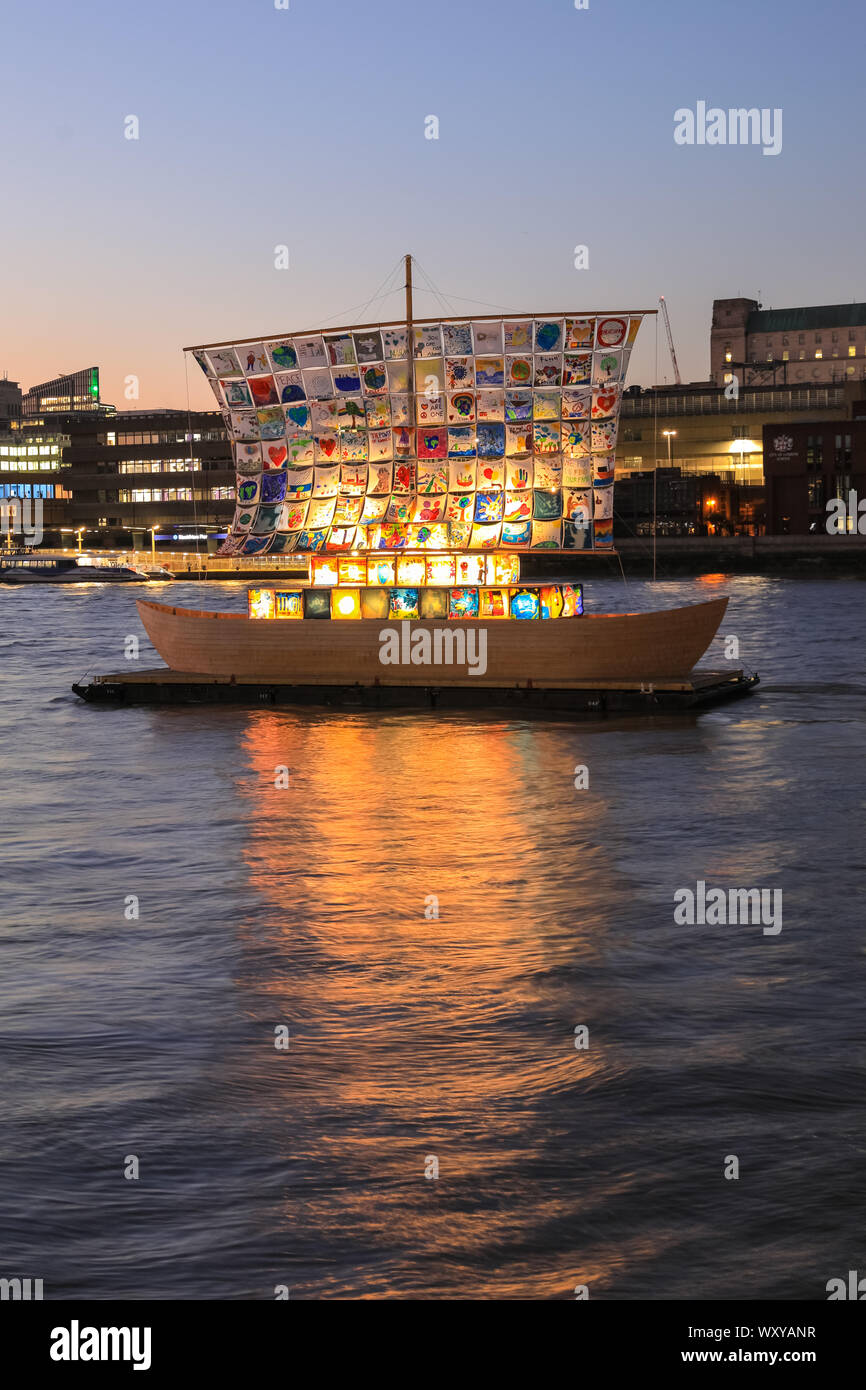 Londres, Reino Unido, 18 sep 2019. El buque de la tolerancia de la instalación en el río Támesis está iluminado contra el cielo azul pastel y suave al atardecer, tras un día cálido y soleado en Londres. Parte de totalmente Thames festival, el buque de la tolerancia es un hermoso barco de madera de 60 pies de la instalación con las obras de arte de los niños de todo el mundo entretejidos para crear sus velas. Fue creado por artistas Ilya y Emilia Kabakov. Crédito: Imageplotter/Alamy Live News Foto de stock