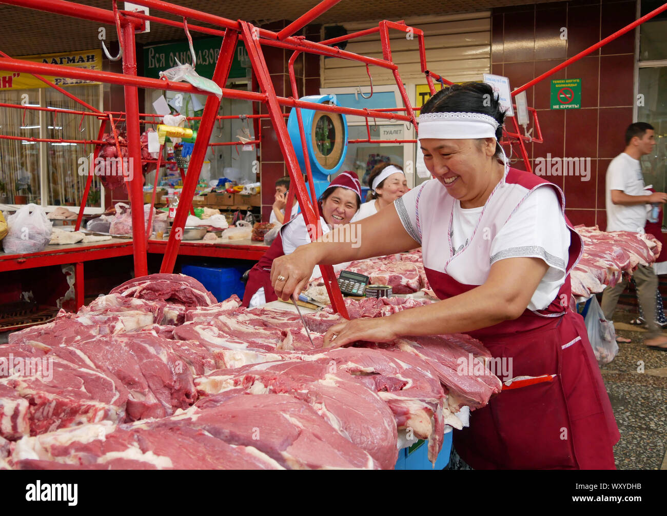 Almaty, Kazajstán - Agosto 24, 2019: sonrientes mujeres que trabajan en la sección de carne del famoso bazar verde en Almaty, Kazajstán Foto de stock