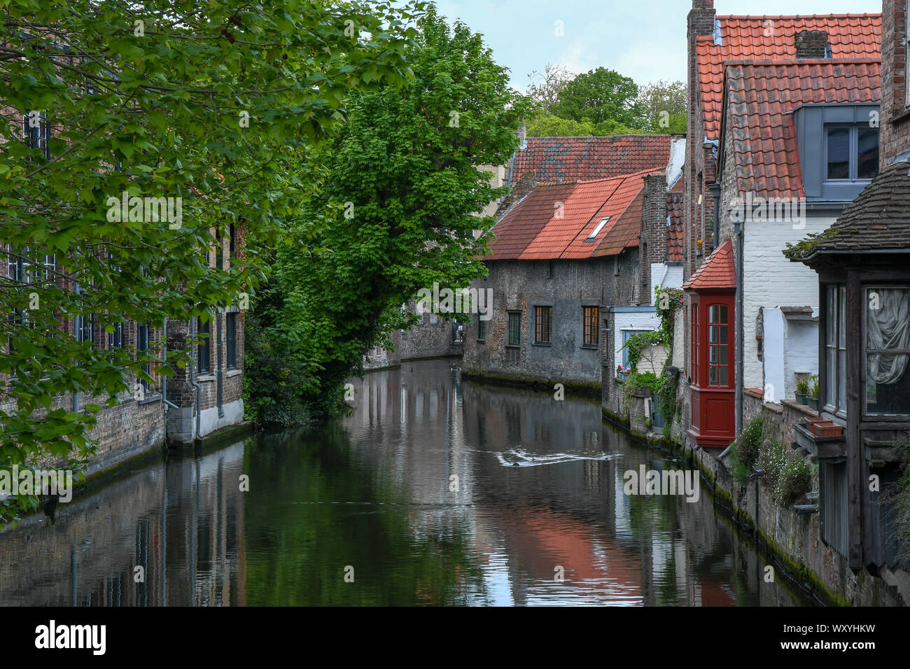 "Pintorescos canales de agua Brugges idílico'-imagen capturada de uno de los románticos puentes durante un paseo en bicicleta explorando la ciudad vieja gemas escondidas. Foto de stock