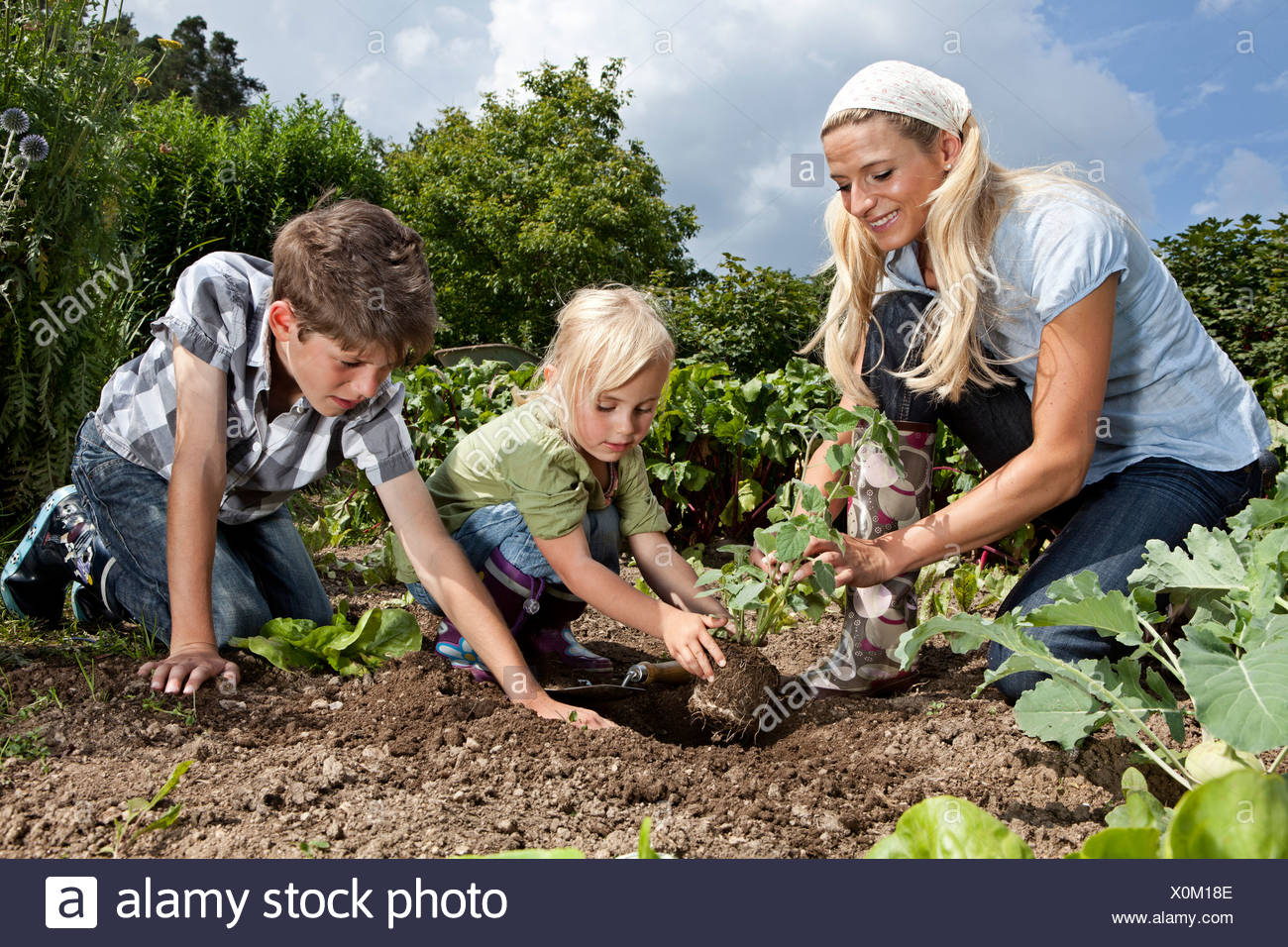 Alemania, Baviera, Altenthann, mujer e hijos juntos en jardinería jardín Foto de stock