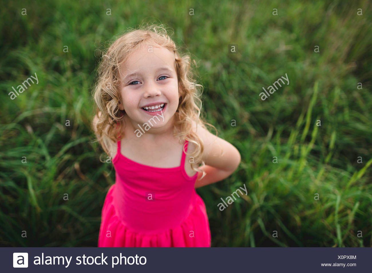 Retrato de la muchacha de los cabellos rubios en hierba Foto de stock