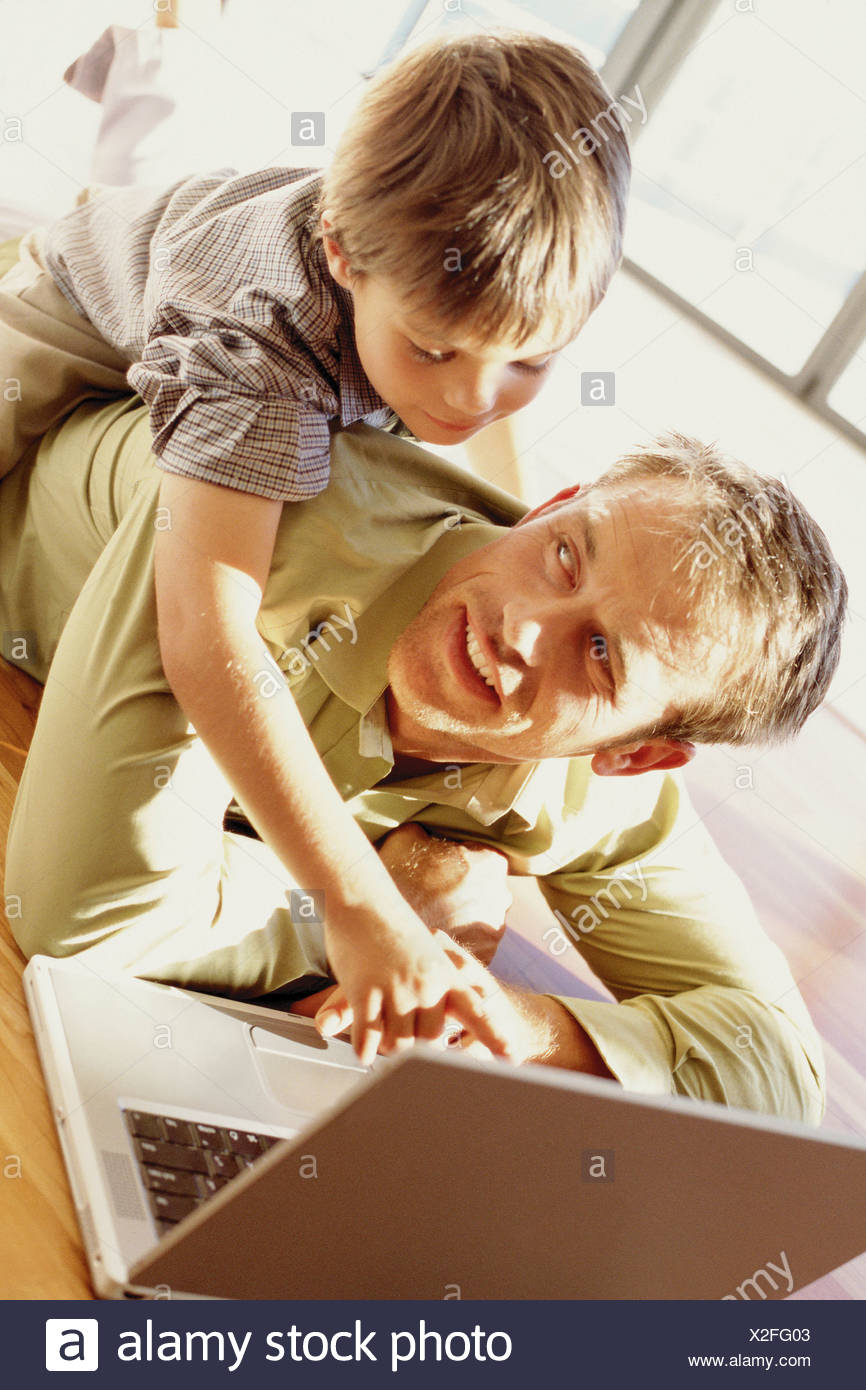 Padre e hijo jugando con un portátil Foto de stock
