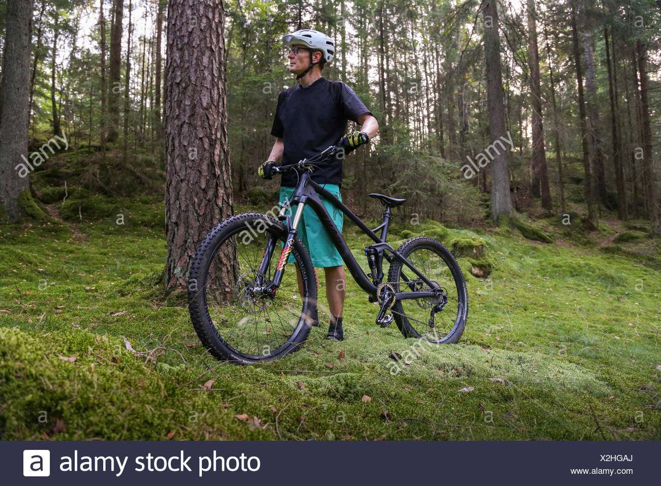 Suecia, Vastergotland, Lerum, hombre maduro con bicicleta en el bosque Foto de stock