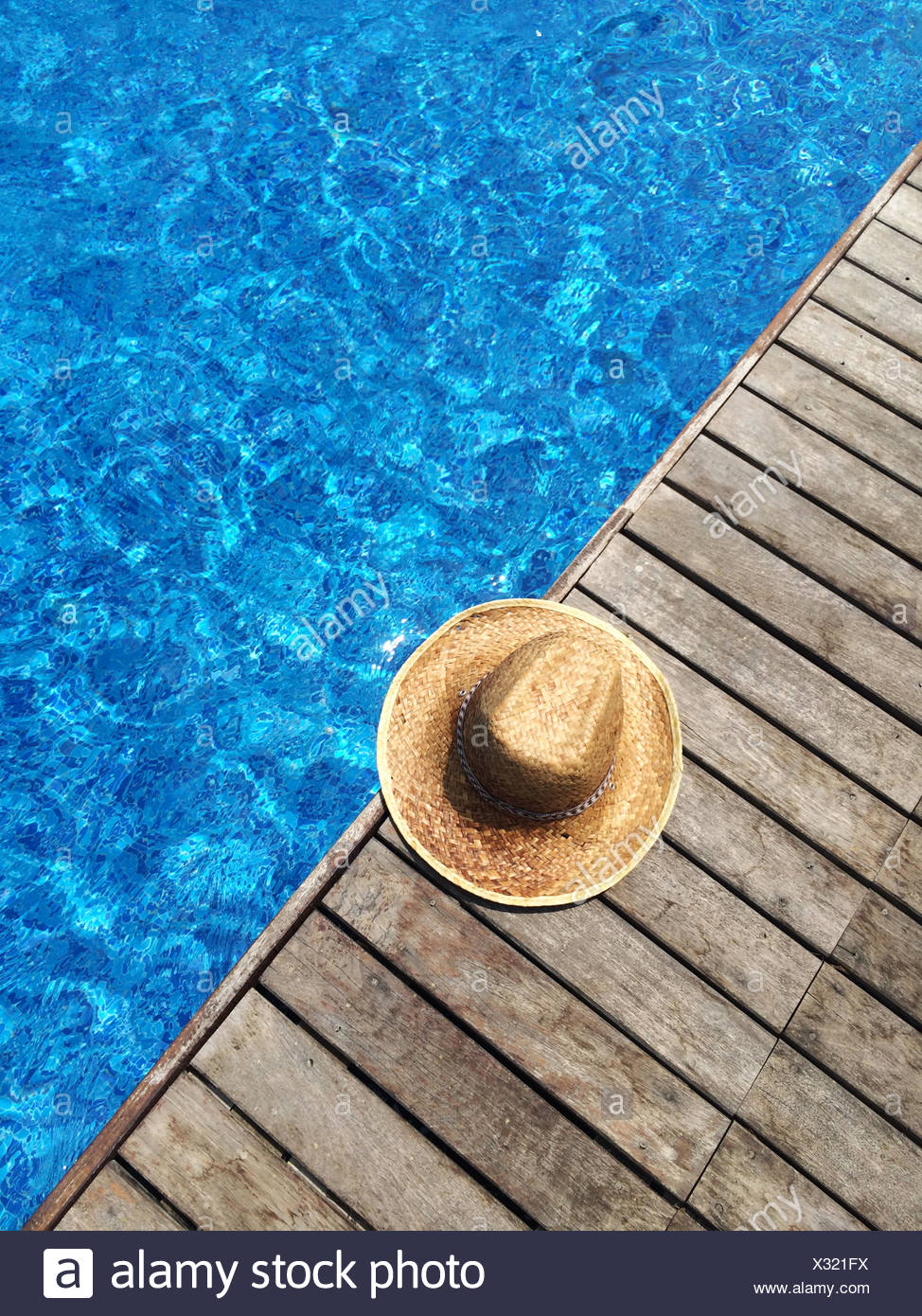 Paja sombrero para el sol por la piscina Foto de stock