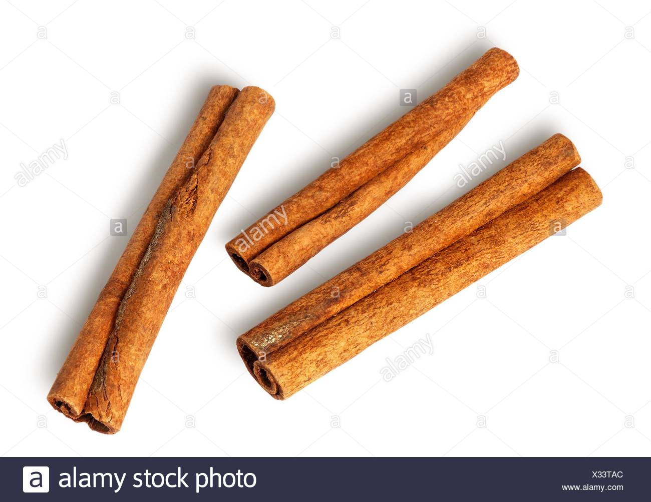 Tres palitos de canela quedan muy cerca aislado sobre fondo blanco. Foto de stock