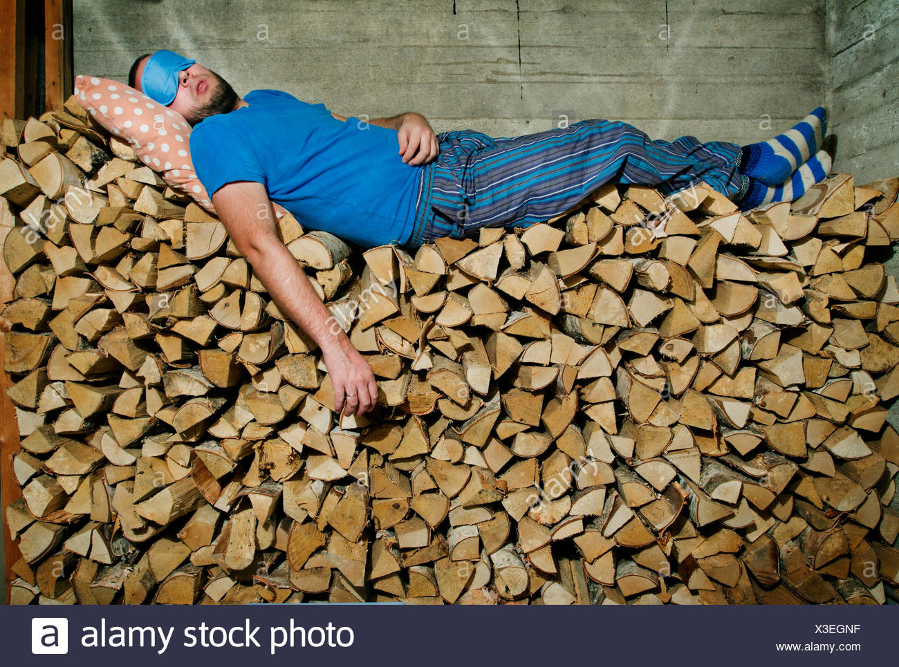 Finlandia, Heinola, hombre dormido sobre la pila de leña Foto de stock