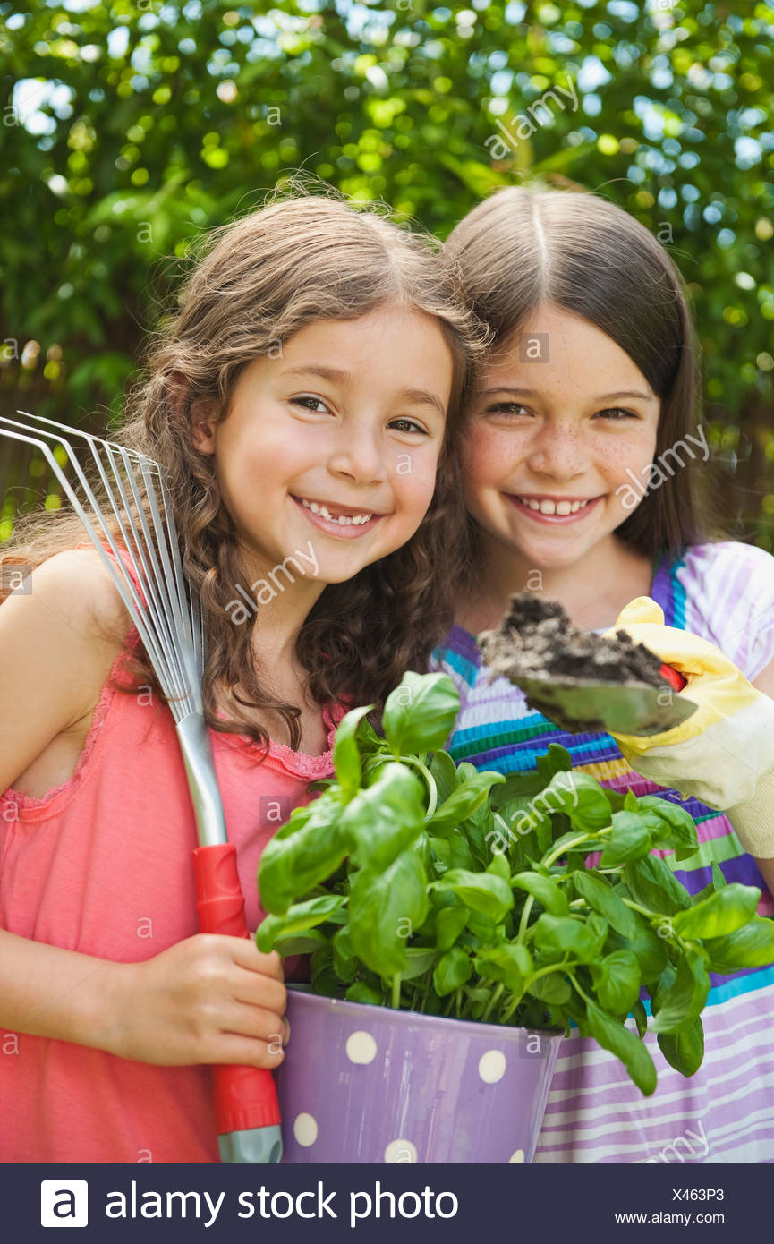 Alemania, Baviera, Hermanas haciendo jardinería en jardín, sonriendo, Retrato Foto de stock