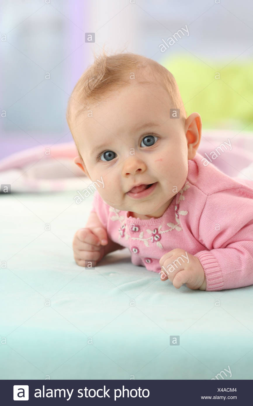 Bebe Nina De 5 Meses Posicion Abdominal Ver La Camara Sonrisa Curiosamente Retrato Modelo Liberado Personas Recien Vestidos Rosa Abdomen Mentira Brillantemente Brazos Manos Anada El Soporte Interior Titulo Fotografia De Stock