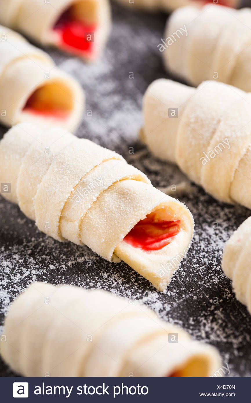 Hacer croissants caseros rellenos con frambuesas dulces Foto de stock