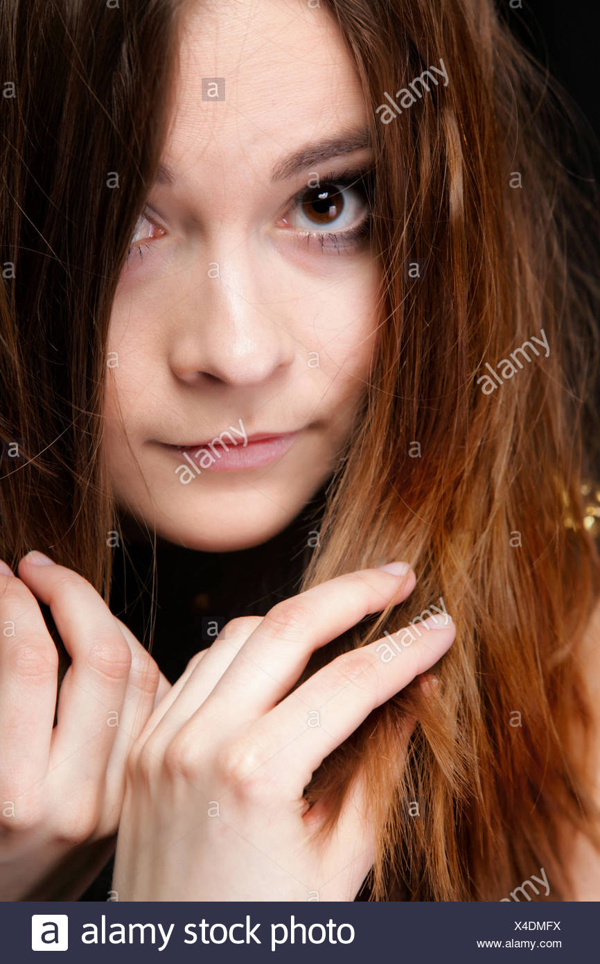 Close-up retrato de una bella mujer cubre el rostro por largos pelos marrones Foto de stock
