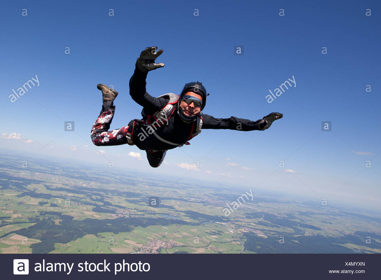 Hombre paracaidismo sobre paisaje rural Foto de stock
