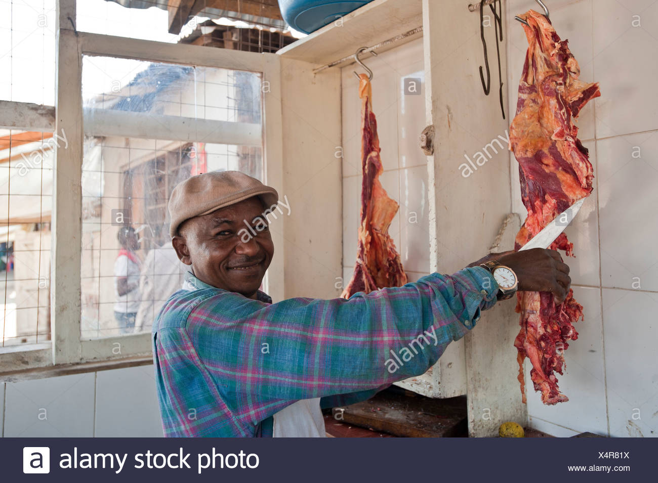 Corte carnicero carne, hombre africano, Tanzania, África Foto de stock