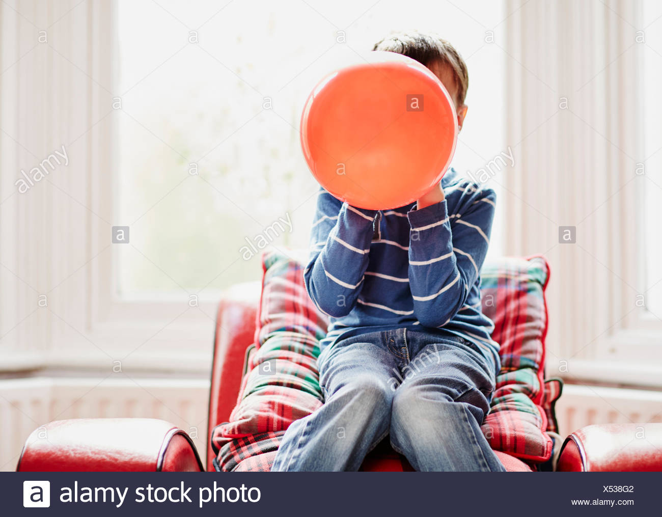Joven la celebración de globo en la parte delantera de la cara Foto de stock