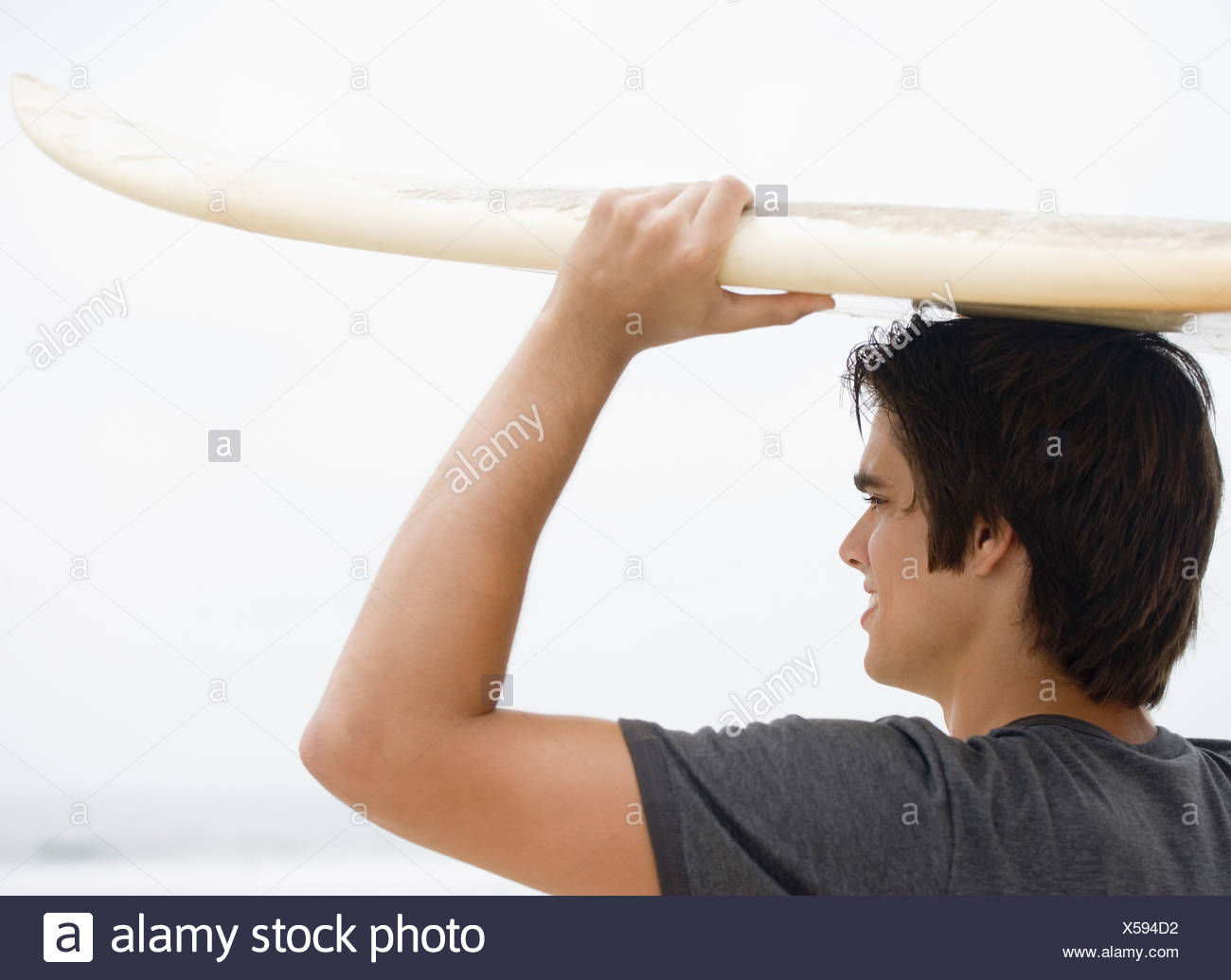 El hombre lleva las tablas de surf en la cabeza. Foto de stock