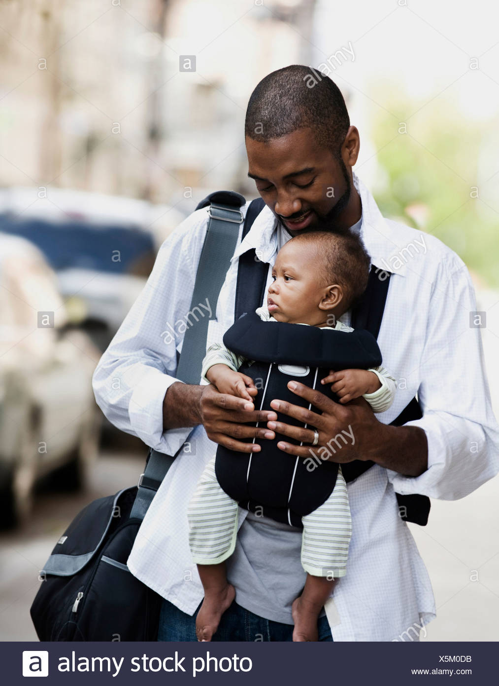 Mitad hombre adulto, llevando a su hijo en baby sling Foto de stock