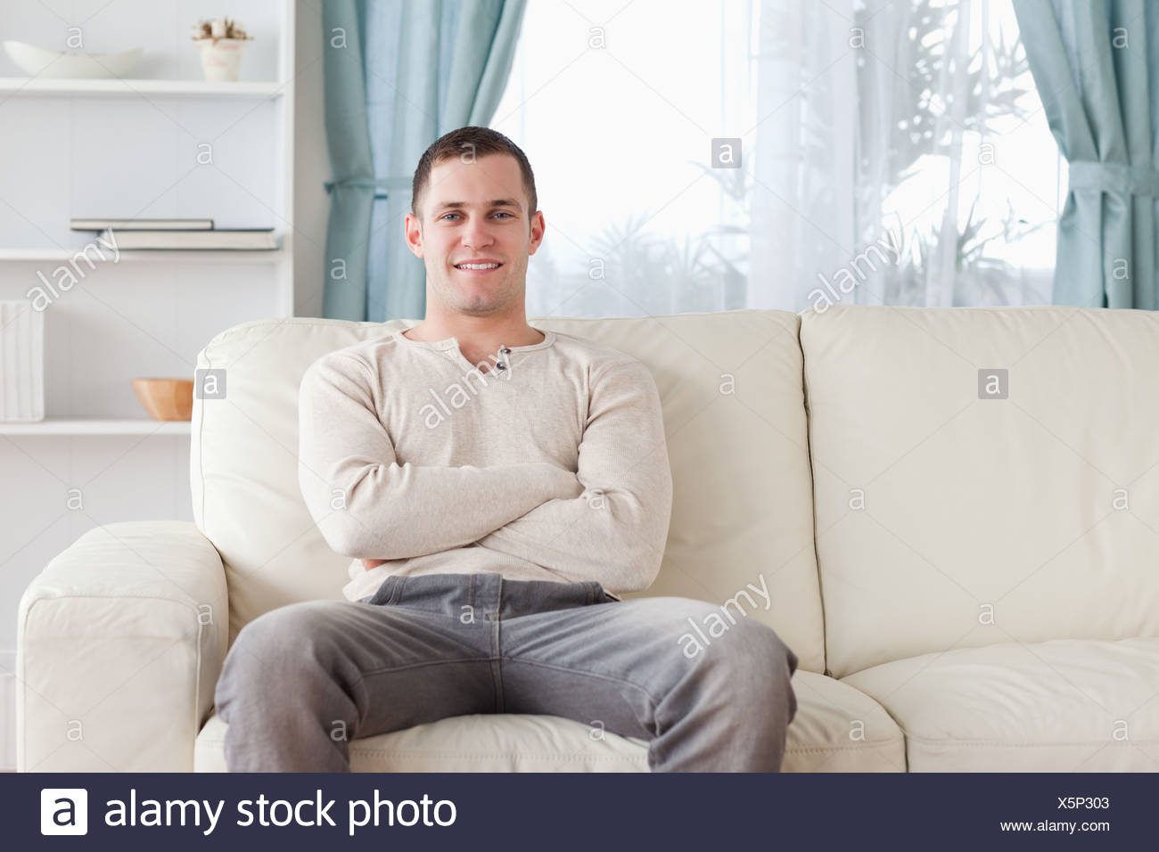 Hombre sentado en un sofá Foto de stock