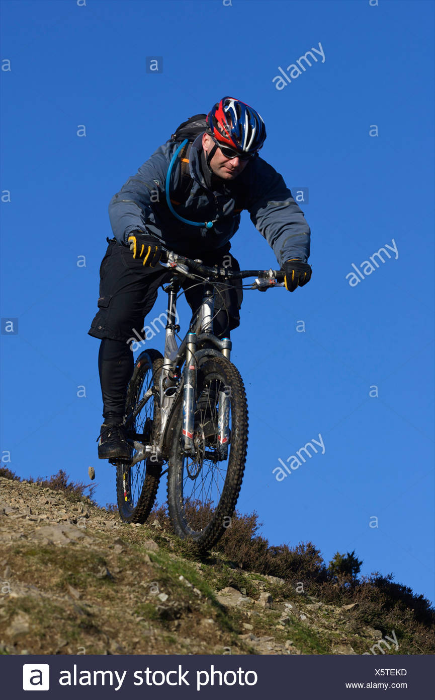 Ciclista de montaña equitación colina abajo. Foto de stock