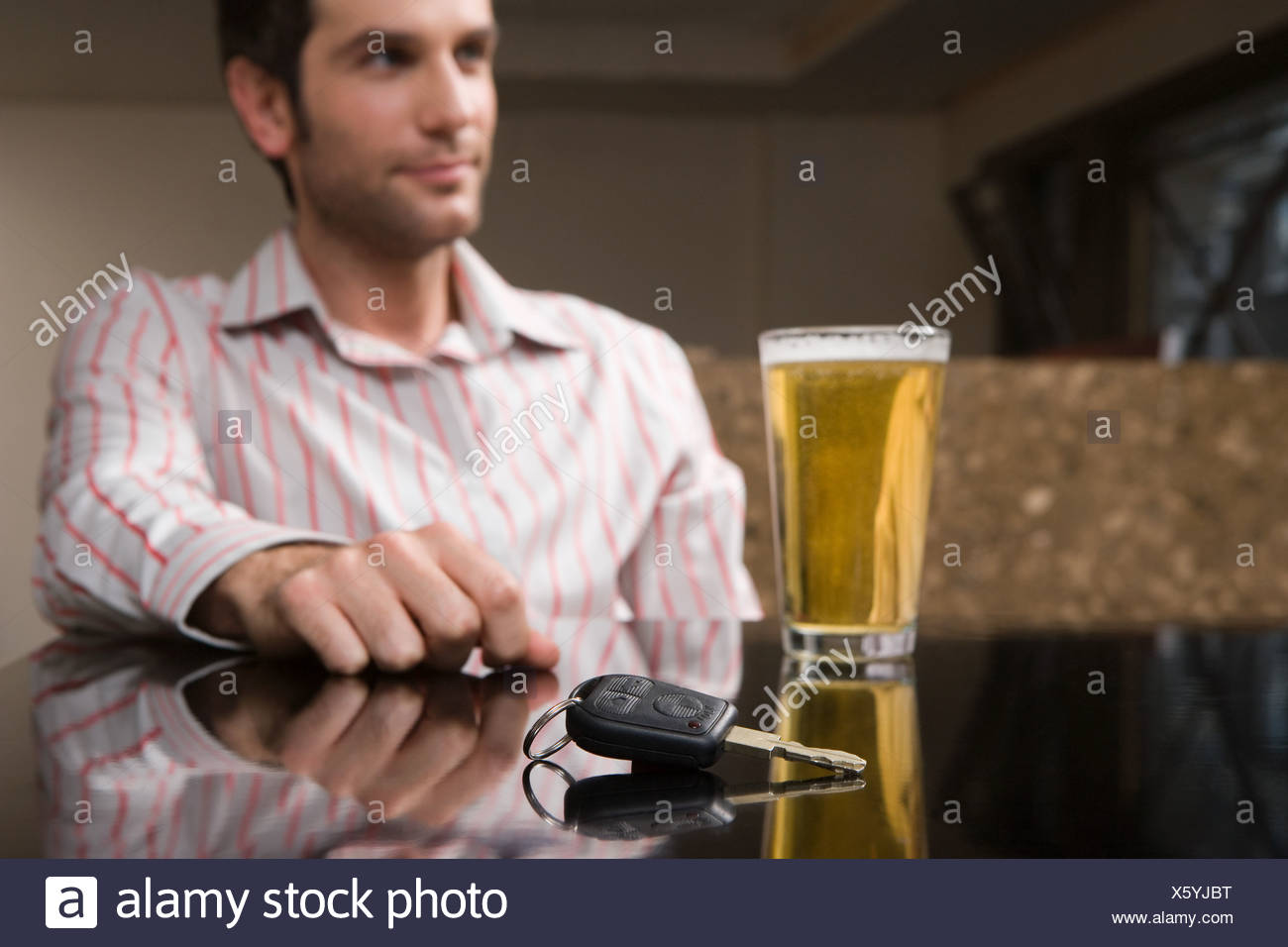 Las llaves del coche y una pinta de cerveza Foto de stock