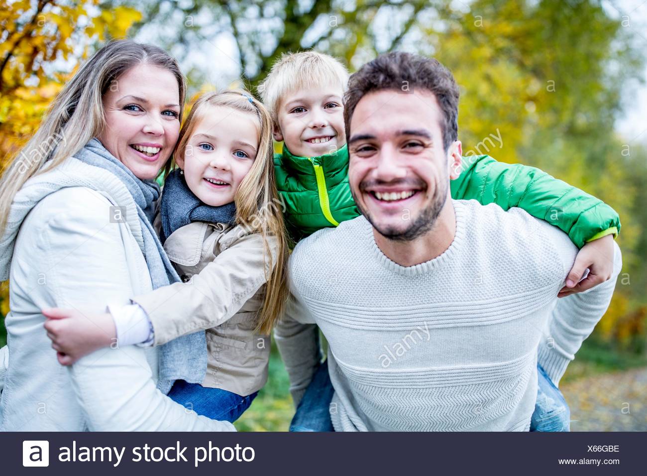 Modelo liberado. Los padres llevan a sus hijos en otoño, retrato, sonriendo. Foto de stock