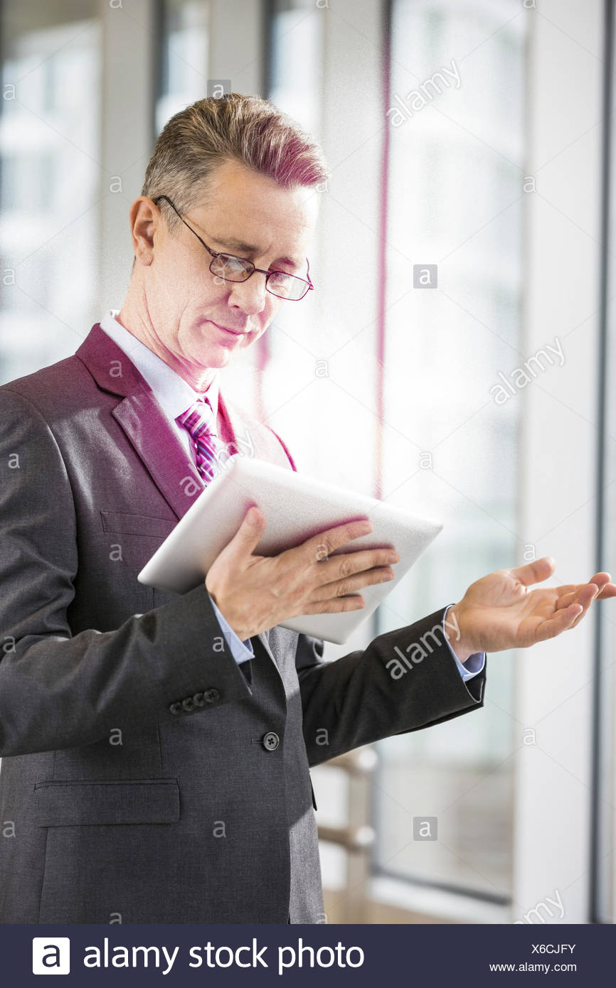 Empresario de mediana edad con tablet PC en la oficina Foto de stock