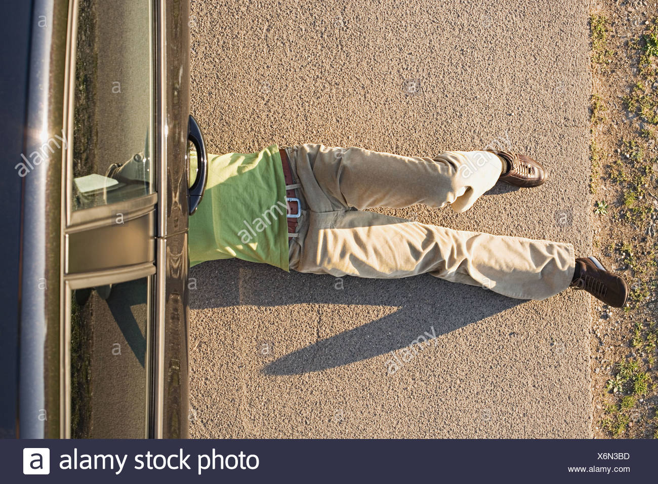 Hombre bajo un auto Foto de stock