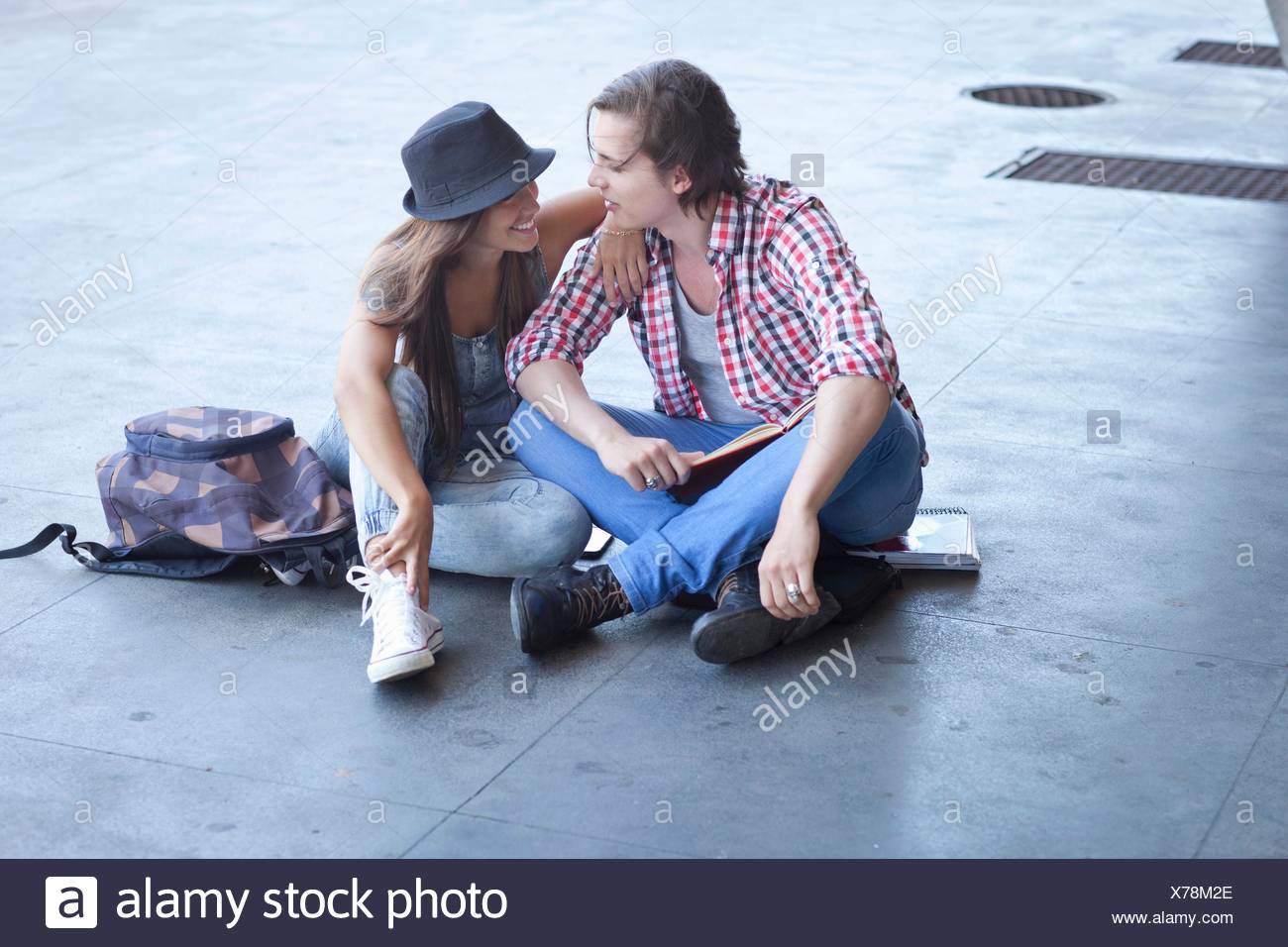 Pareja joven sentado en el suelo Foto de stock