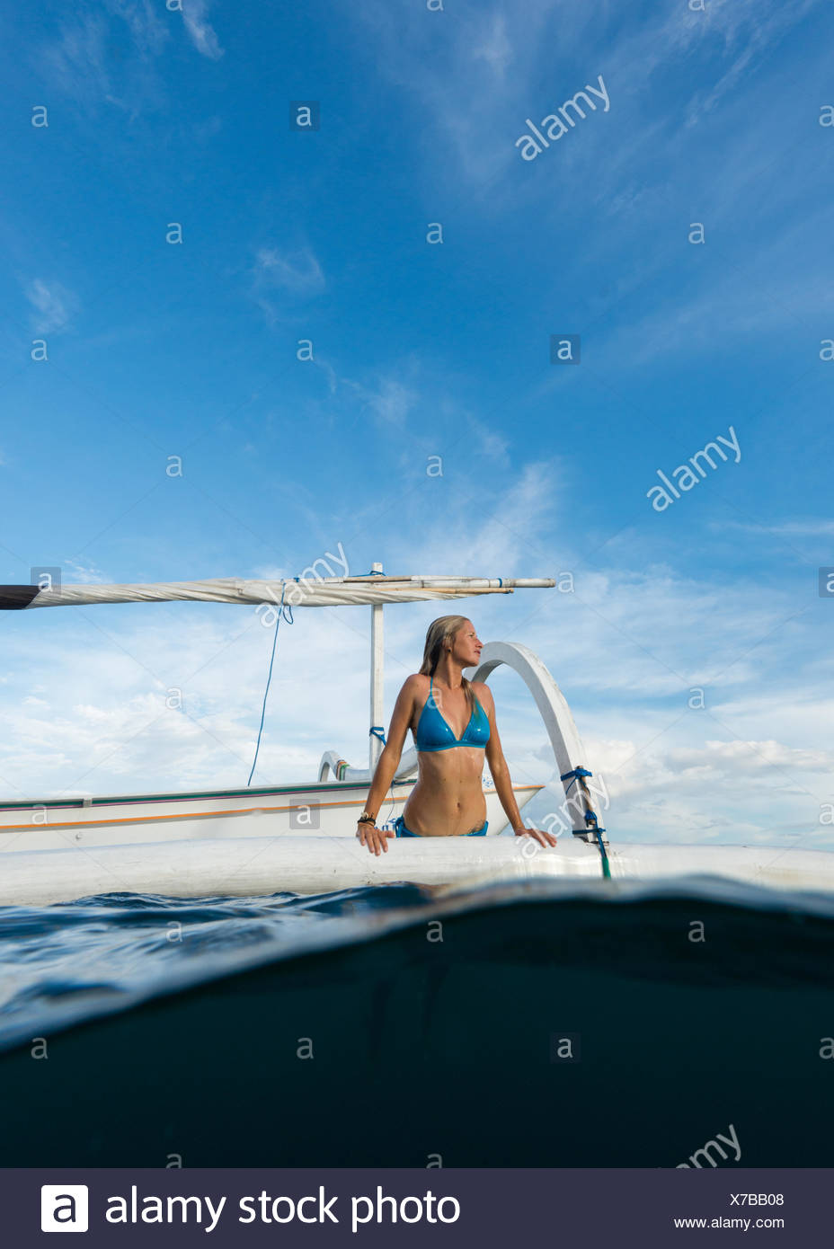 Mujer saliendo del mar en un barco, Bali, Indonesia Foto de stock