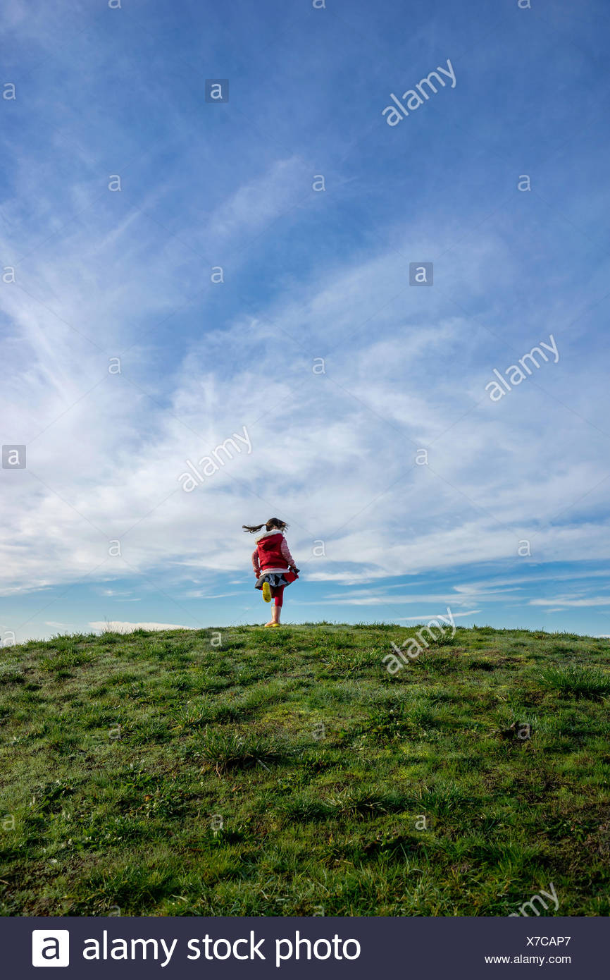 Chica en una colina girando en torno a Foto de stock