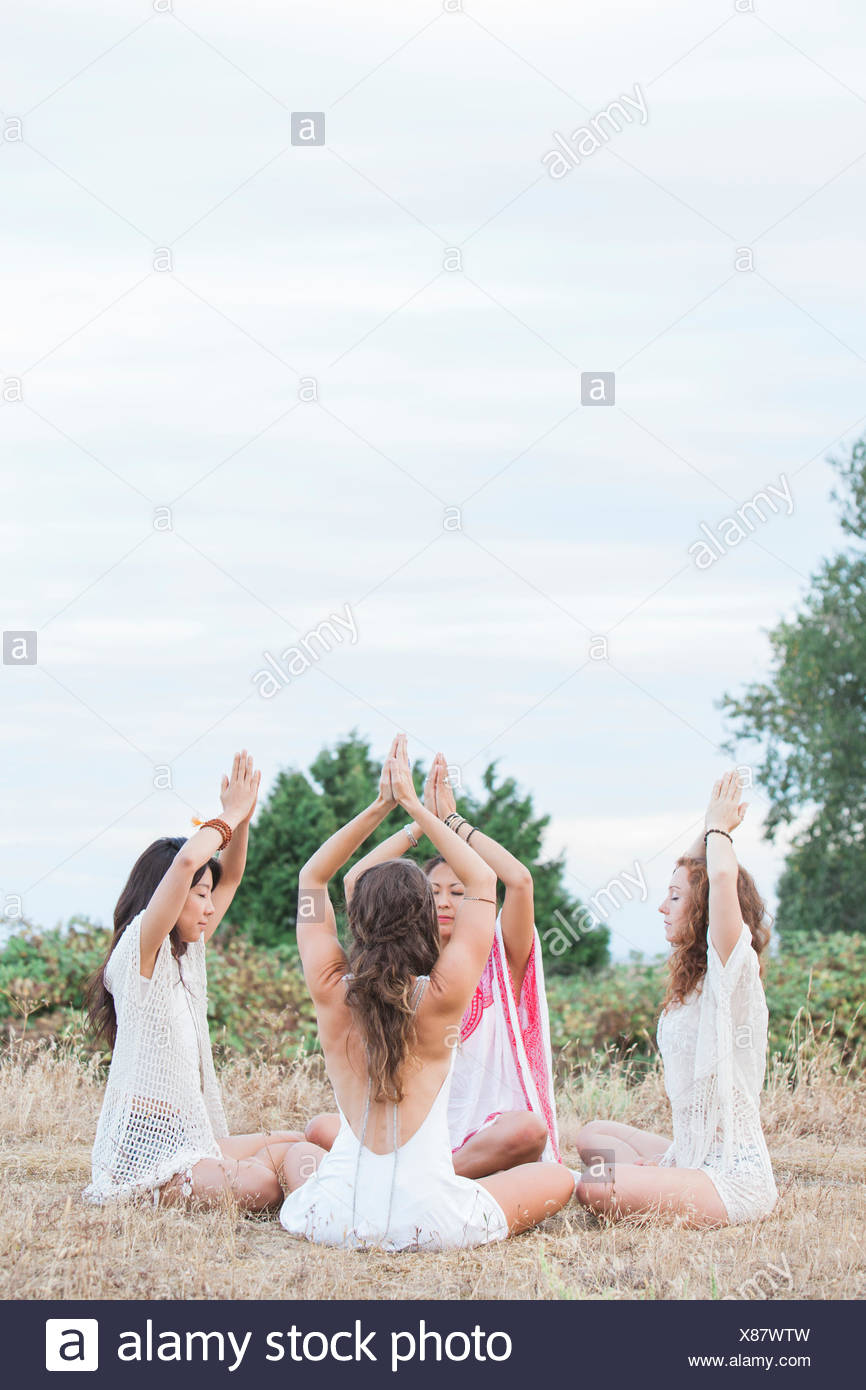Boho mujer meditando con las manos entrelazadas sobrecarga en círculo en ámbito rural Foto de stock