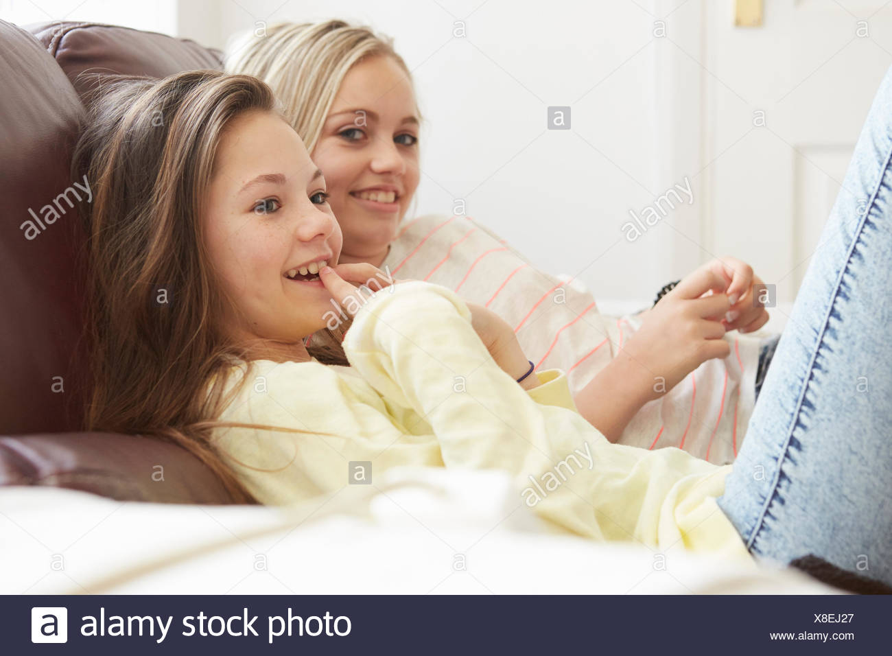 Dos niñas viendo la televisión desde el sofá Foto de stock