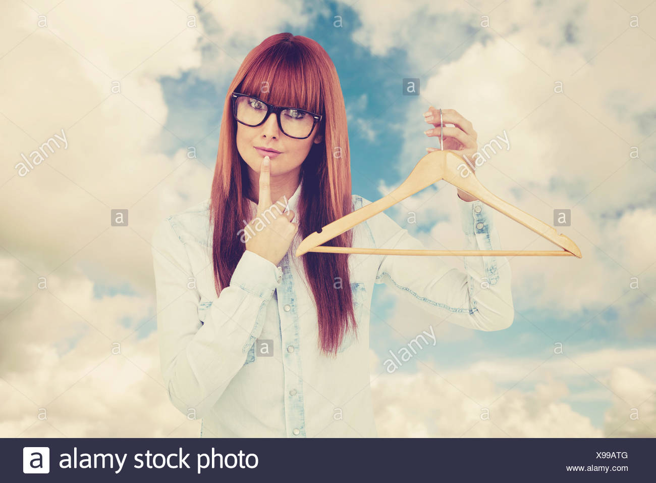 Imagen compuesta de sonriente hipster mujer sosteniendo un perchero Foto de stock