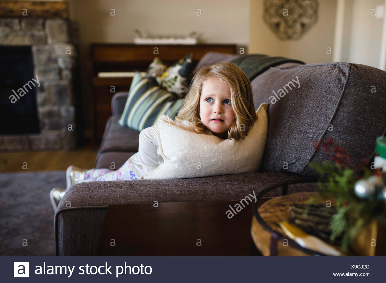 Temerosos girl looking sideways de SOFA Foto de stock