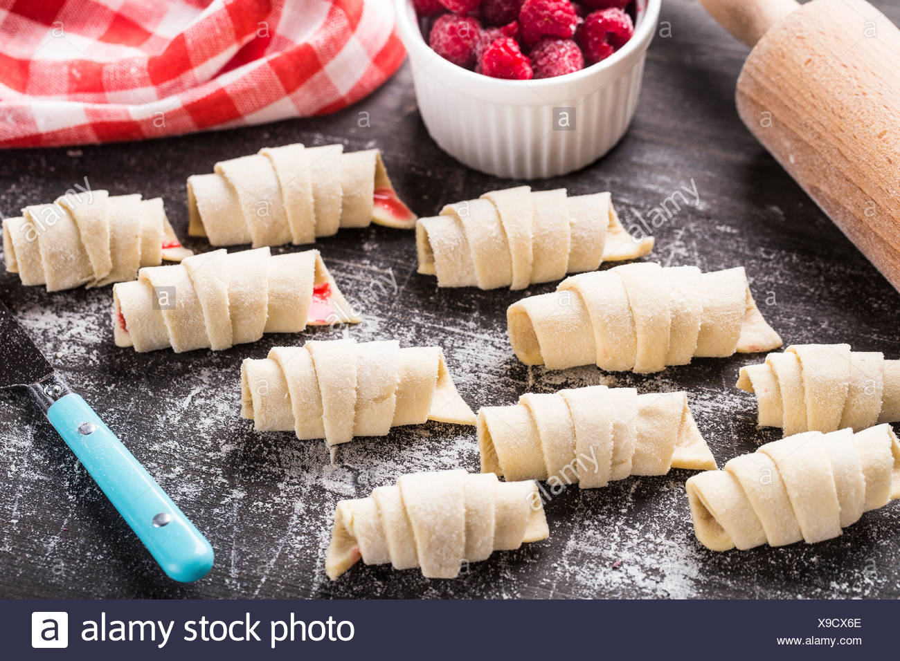 Hacer croissants caseros rellenos con frambuesas dulces Foto de stock