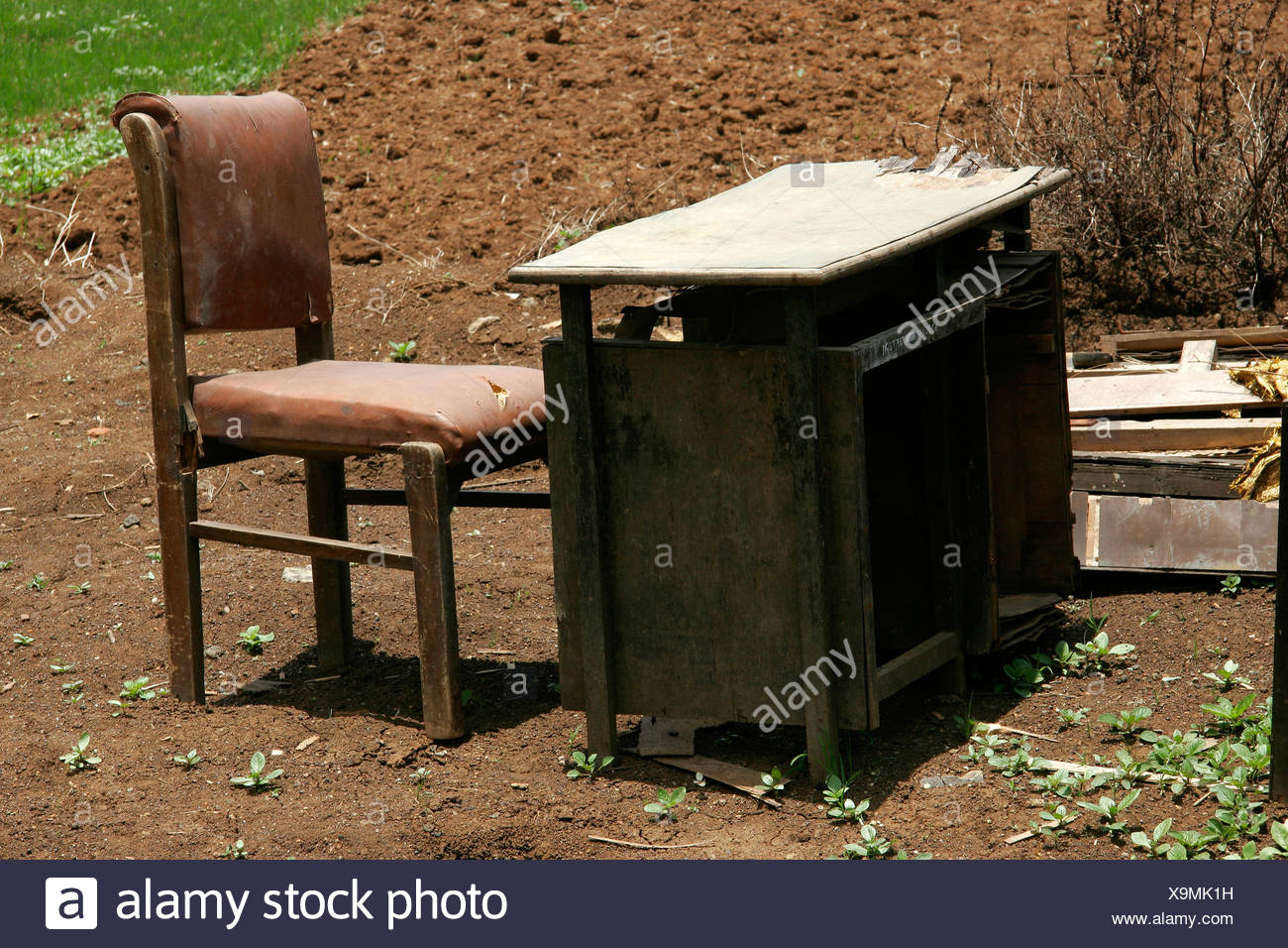 Mesa y silla artificiales en etapa rota dispuestos en la naturaleza Foto de stock