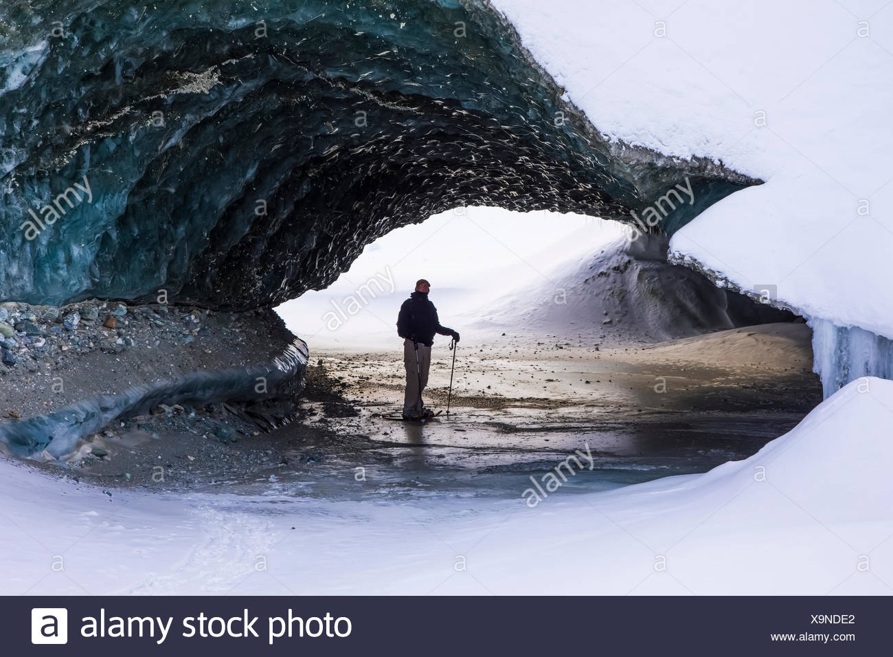 Un hombre en raquetas de nieve está debajo del hielo del glaciar Canwell en la Cordillera de Alaska en invierno, Alaska, Estados Unidos de América Foto de stock