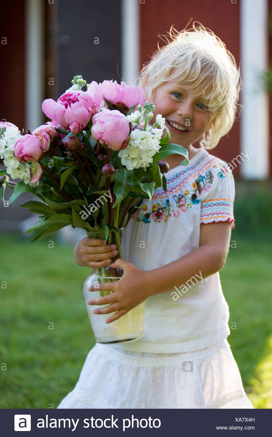 Niña sosteniendo un ramo de flores, Fejan, archipiélago de Estocolmo, Suecia. Foto de stock