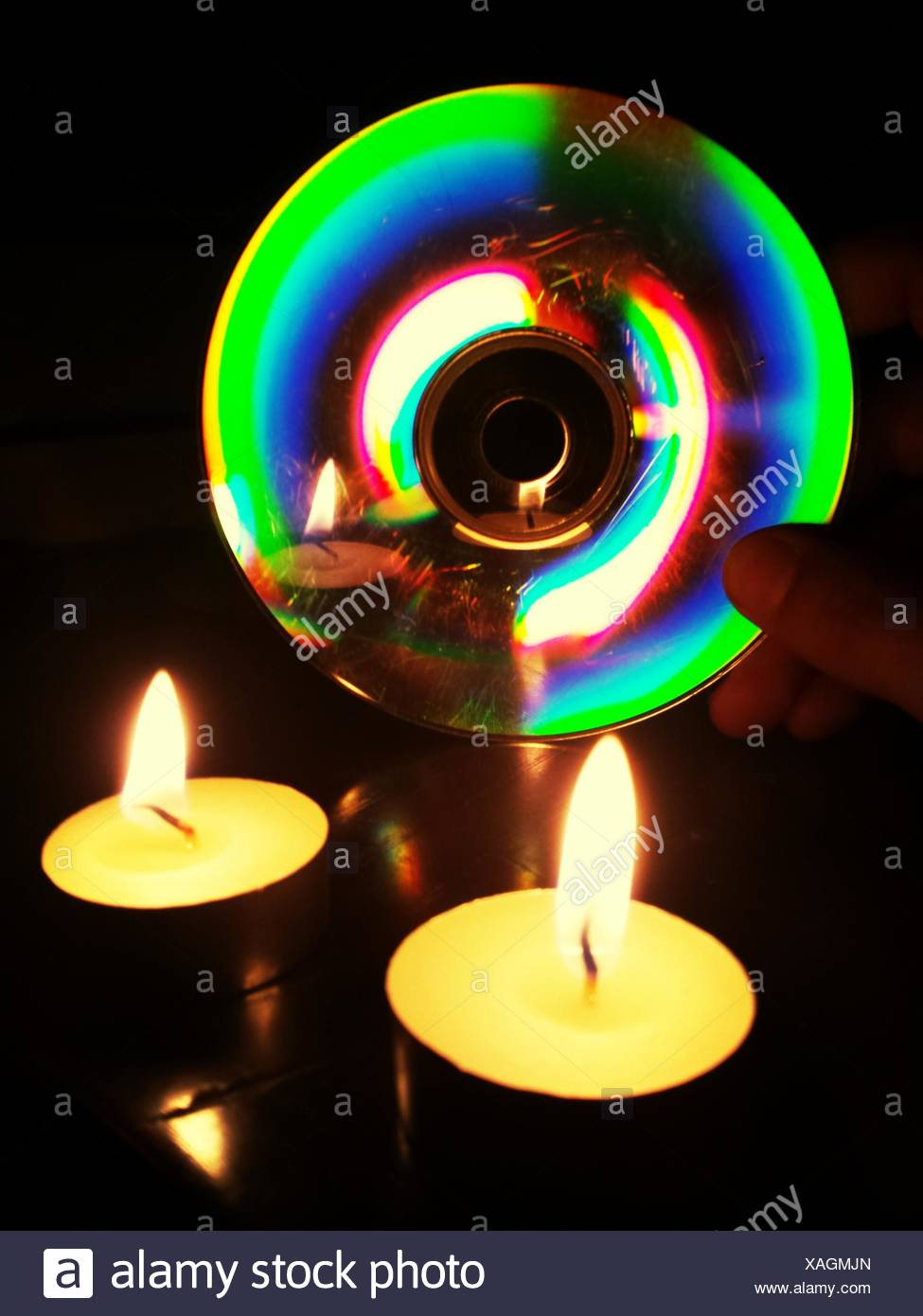 A la luz de las velas que refleja en disco compacto Foto de stock
