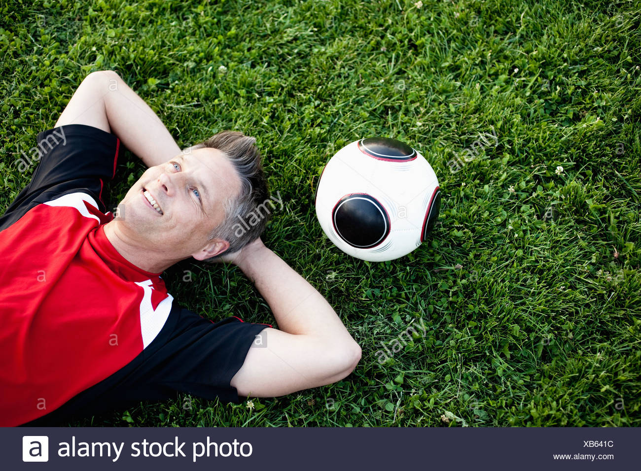 Jugador de fútbol sobre hierba relajante Foto de stock