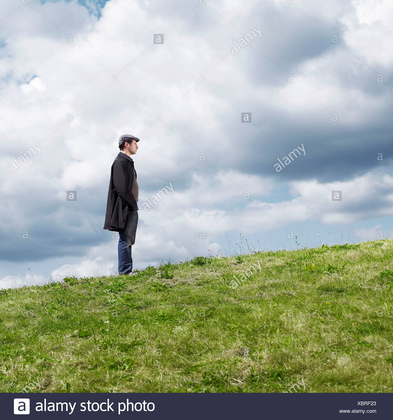 Hombre de pie en la colina solitaria Foto de stock